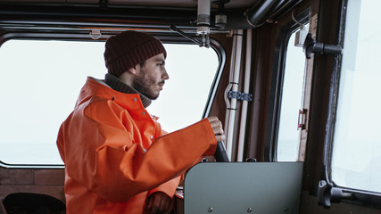 Captain Pilots Commercial Fishing Ship in His Cabin.