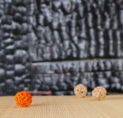 decorative rattan balls against a charred wooden wall