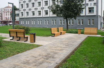 Obraz premium Yellow park benches in the city on the boulevard.