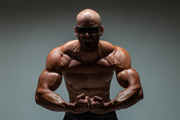 Brutal strong athletic bodybuilding men posing in studio. Bodybuilding and healty life concept. 