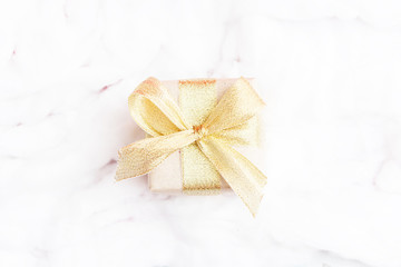 Christmas gift on a background of white snow made of cotton, for advertising, close up