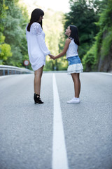 Obraz premium Pretty mother and daughter walking on the mountain road