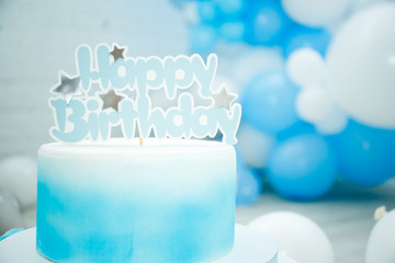 Beautiful decor for the birthday of the boy, a blue cake with the inscription from rhinestones happy birthday. Balloons, copy space, space for text, birthday concept