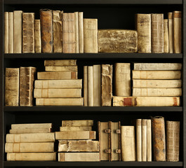 ancient books on wooden shelf in a private library.