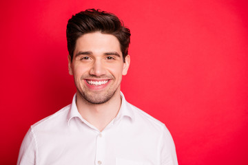 Close up photo of charming person with beaming smile wearing white shirt isolated over red background
