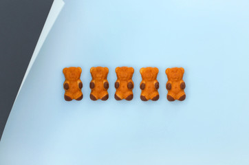 A row of cakes in the shape of a bear on a blue background.