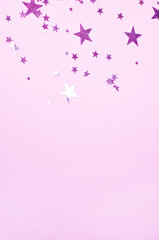 Vertical pink background with star shaped confetti.
