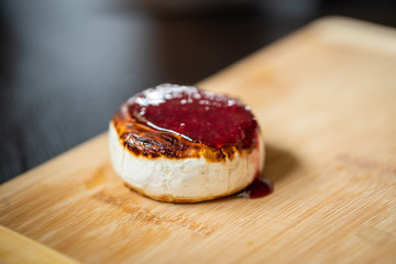 Close up shot of fried camemebert cheese with rapsberry dressing