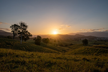 As the sun sets it casts beautiful colours and shadows across the farm fields and landscape of Murwillumbah, NSW, Australia