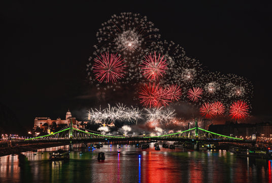 Colorful red fireworks over Budapest, River Danube with bridges, night