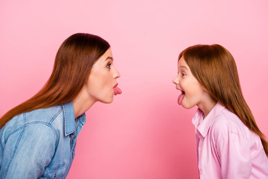 Pretty foxy little lady and her mom making silly facial expressions wear casual jeans clothes isolated pink background