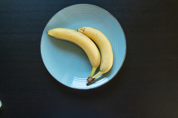 Diet concept - two bananas on the blue plate