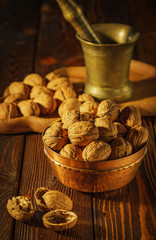 Walnuts, decorticated walnuts and walnut shells on wooden background