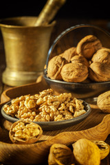 Walnuts, decorticated walnuts and walnut shells on wooden background