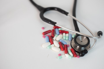 estetoscopio y pastillas de antibióticos, vitaminas y quimioterapia