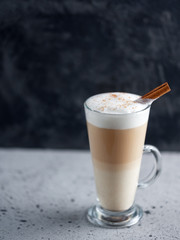 a glass of latte coffee on a concrete table