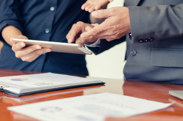 Business managers using pen pointing to tablet discussion information projects with young woman at office