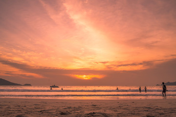 Fototapeta na wymiar Sunset lovers, bright orange sky, on the beach Famous Phuket Patong Thailand