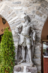 Obraz premium Statue of a knight at the entrance to the bar Regal located near Pelesh castle in Sinaia, in Romania