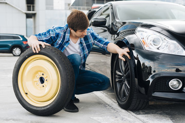 Man swapping car tire with spare