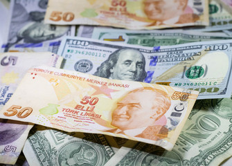 American dollar and Turkish lira banknotes laid out as background.