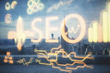 SEO hologram on city view with skyscrapers background double exposure. Search optimization concept.