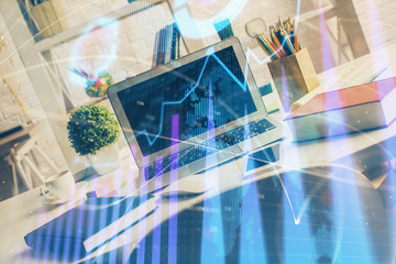 Financial graph colorful drawing and table with computer on background. Multi exposure. Concept of international markets.