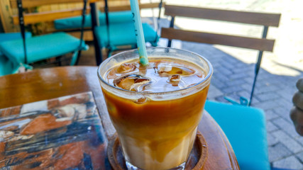cold coffee with ice cubes and pipette in a coffee shop
