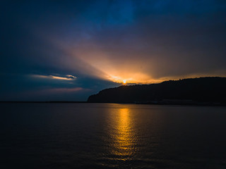 Beautiful orange sunset over the sea on a summer evening under a cloudy sky.