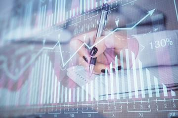 Multi exposure of hands making notes with forex chart huds. Stock market concept.