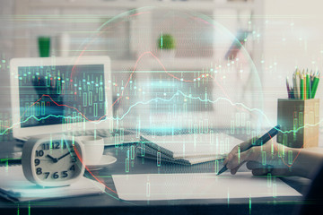 Financial graph displayed on woman's hand taking notes background. Concept of research. Multi exposure