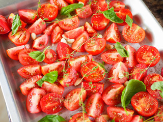 tomatoes with provencal herbs, basil, thyme and garlic. Vegetarian zucchini, tomatoes and bell pepper sauce, and ceramic tomatoes with herbs before baking. View from above. Close