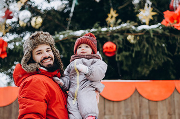 Happy loving family! Father and his baby are playing and hugging outdoors. Cute little child and daddy on snowy winter walk in nature. Concept of frost winter season.