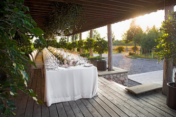 Outdoor wedding celebration at a restaurant. Festive table setting, catering. Wedding in rustic style in summer, beautiful small bouquets on a table.
