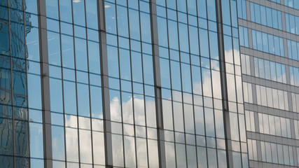 Plakat reflection of a blue sky with clouds in the glass of a skyscraper