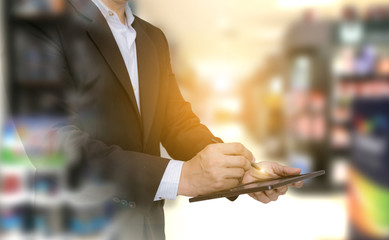 Double exposure business of checking products as hand holding the tablet in the warehouse