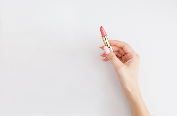 Lipstick in woman's hands on white background. Make up. Open space. 