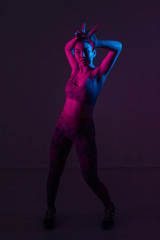 Portrait of a young dancer in bright color light in the Studio