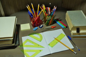 Back to school concept with empty checkered exercise book for homework, pen, pensil, compass,...