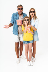 Fototapeta premium Photo of shocked family in 3D glasses holding popcorn bucket while watching movie in cinema