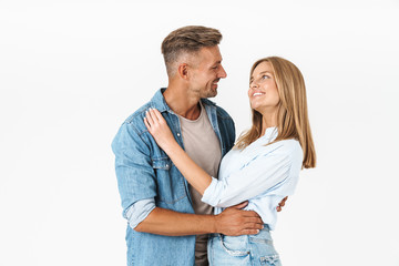 Portrait of lovely caucasian couple man and woman in basic clothing smiling and hugging together
