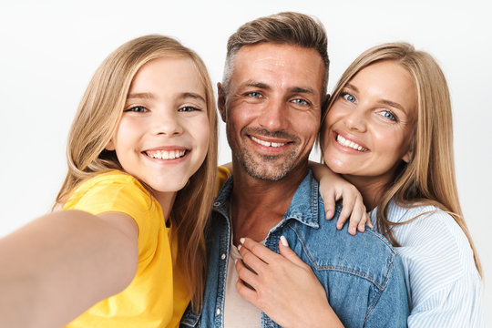 Image of attractive caucasian family woman and man with little girl smiling and taking selfie photo together