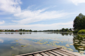 View from wooden bridge on cloudy sky and blue river