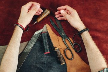 Close up of a shoemaker working with leather. New idea for leather products. Small business. Handmade, leather craft workshop