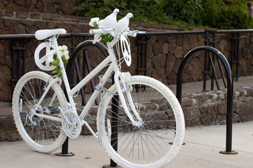Fototapeta na wymiar White peace bike chained up to a parking spot