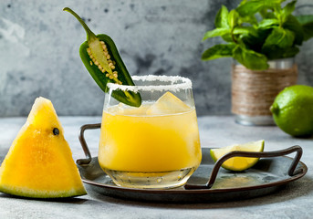 Spicy golden watermelon margarita cocktail with jalapeno and lime. Mexican alcoholic drink for Cinco de mayo party