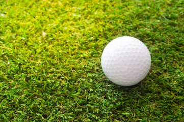 Close-up golf ball on green grass.