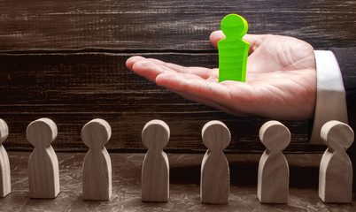 Businessman holds out a new leader in front of employees. Team building and business hierarchy....