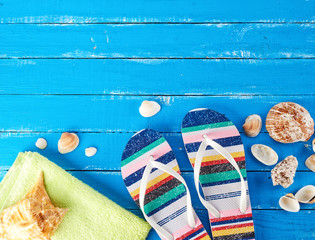 pair of female beach slippers and a green towel