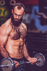 Fototapeta na wymiar Muscular bearded fitness man workout with barbell in gym